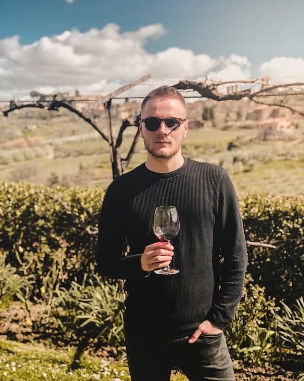 máté schubert holding glass off wine in tuscany